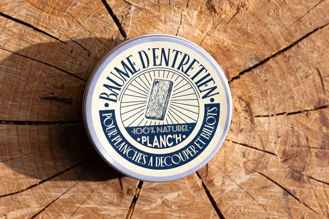 Baume d'entretien 100 % naturel Planch'h pour planche à découper posé sur un billot en bois