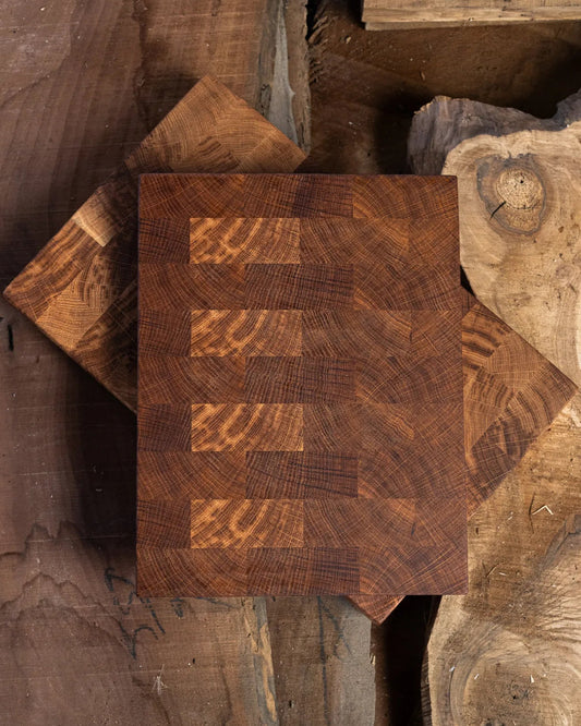 Planches à découper en chêne bout de grain posées sur bois brut, motif brique