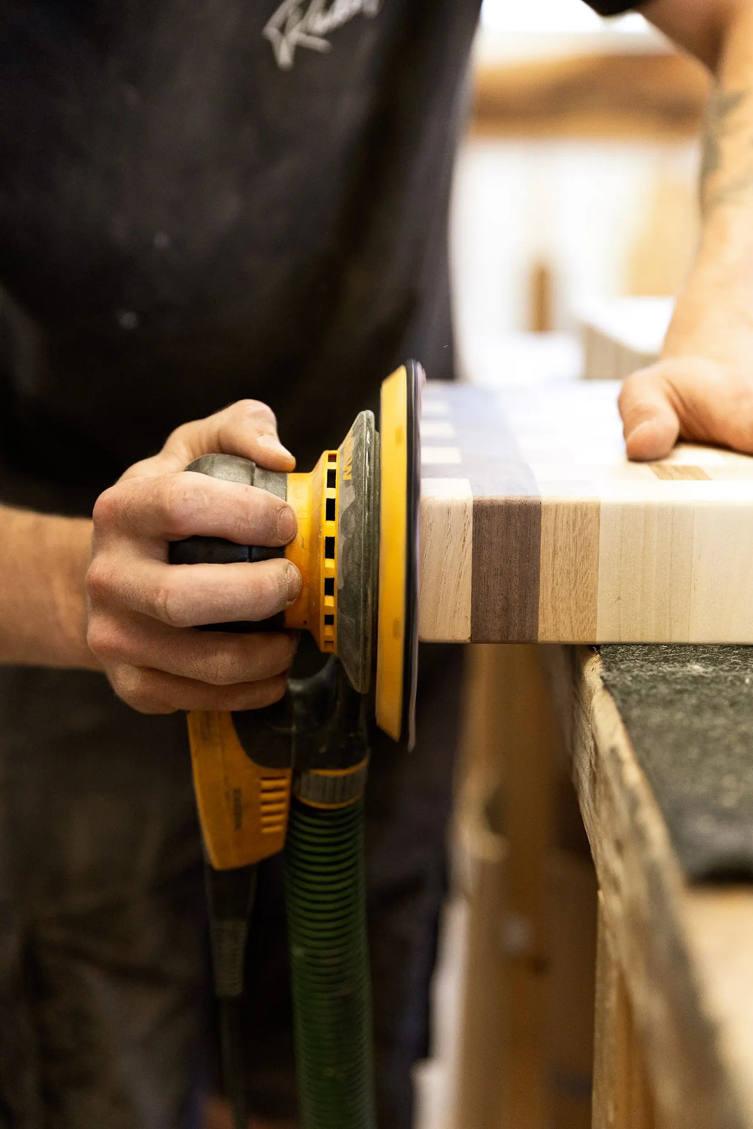 Ponçage artisanal d'une planche à découper à l'atelier Planc'h